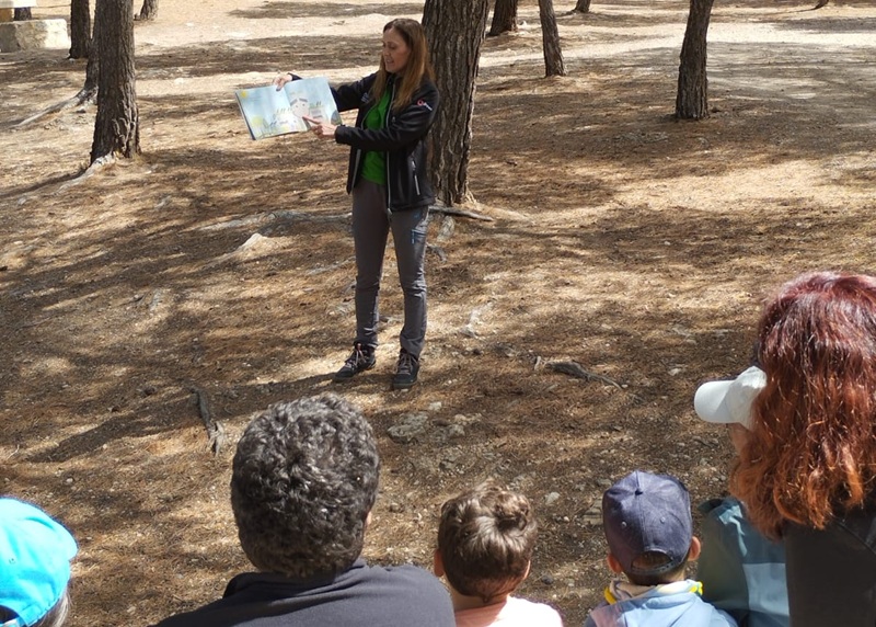 mujer exponiendo ante personas en un bosque