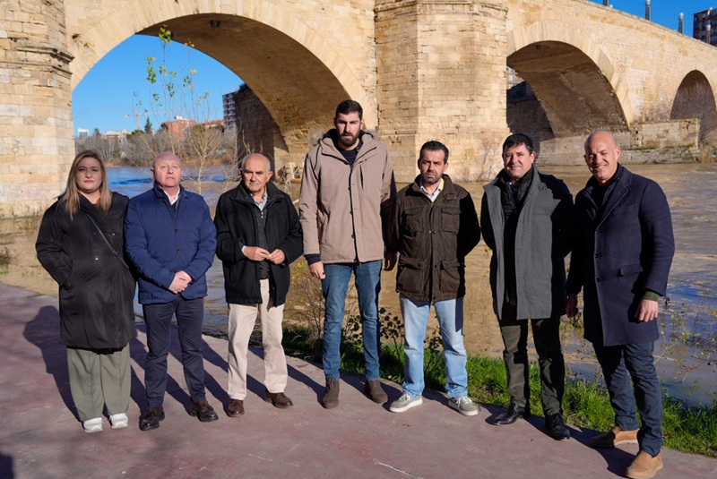 Grupo de personas con un puente y un rio al fondo