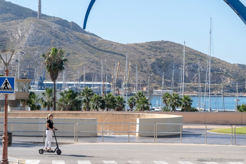 mujer en patinete electrico por el puerto